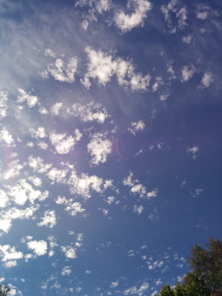 A clear blue sky adorned with scattered white clouds, a metaphor of our mind.